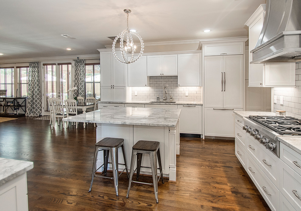 Open concept kitchen - large transitional u-shaped medium tone wood floor open concept kitchen idea in Dallas with an undermount sink, shaker cabinets, white cabinets, quartz countertops, white backsplash, porcelain backsplash, stainless steel appliances and an island