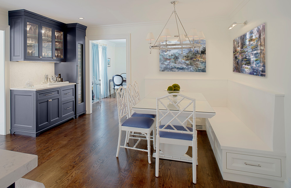 Inredning av ett klassiskt mellanstort vit vitt kök, med blå skåp, bänkskiva i kvarts, vitt stänkskydd, luckor med infälld panel, mörkt trägolv och brunt golv