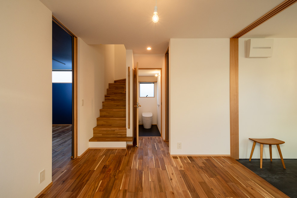 Immagine di un corridoio scandinavo di medie dimensioni con pareti bianche, pavimento in legno massello medio, una porta scorrevole, una porta nera, pavimento beige, soffitto in carta da parati e carta da parati