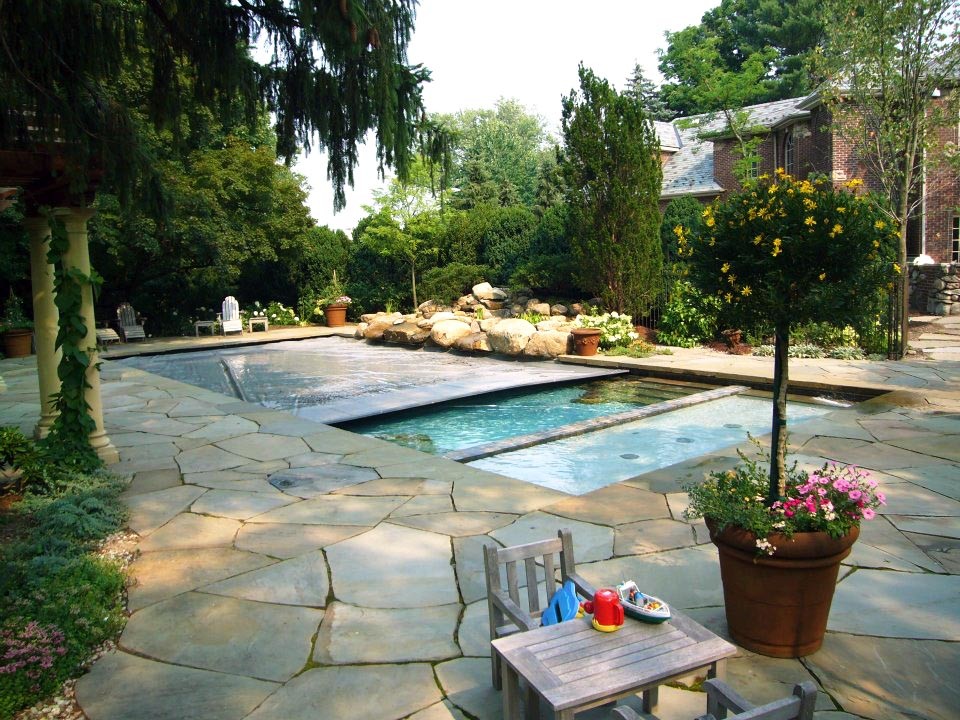 Inspiration for a modern backyard rectangular lap pool in New York with natural stone pavers and a hot tub.