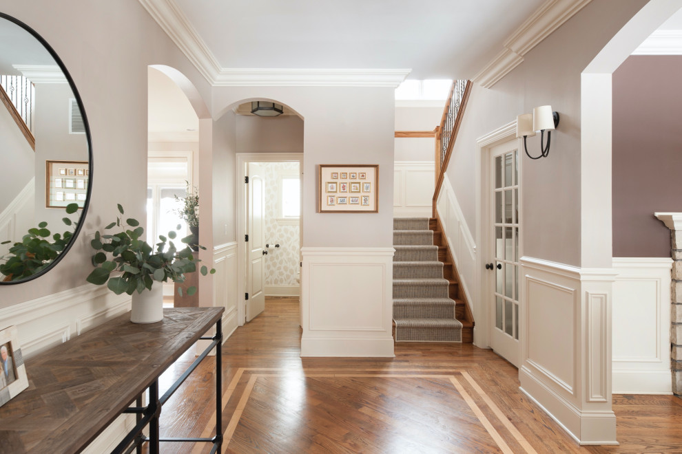 Photo of a transitional foyer in Chicago with grey walls, medium hardwood floors, brown floor and decorative wall panelling.