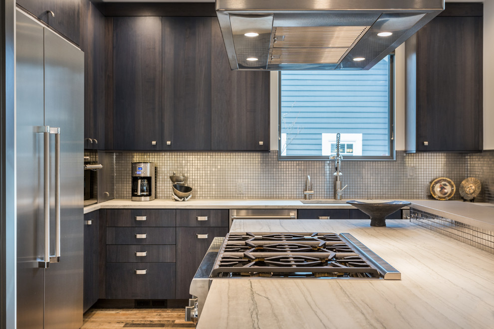 Design ideas for a large contemporary u-shaped open plan kitchen in Portland with a farmhouse sink, flat-panel cabinets, black cabinets, beige splashback, stainless steel appliances, light hardwood floors, with island and beige floor.