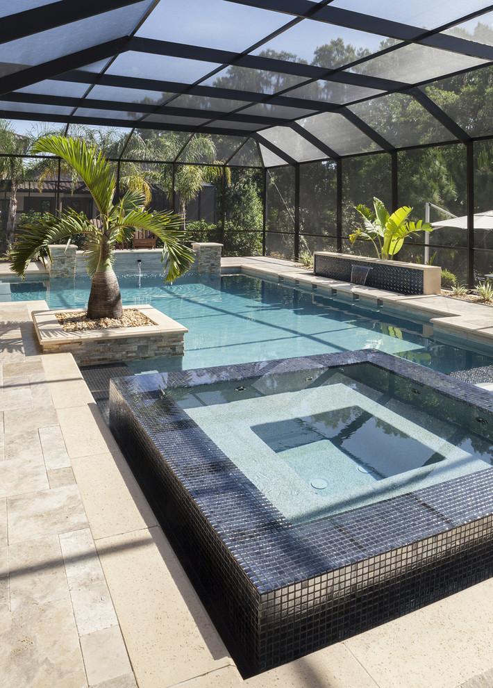 Photo of a large contemporary indoor l-shaped lap pool in Tampa with a hot tub and tile.