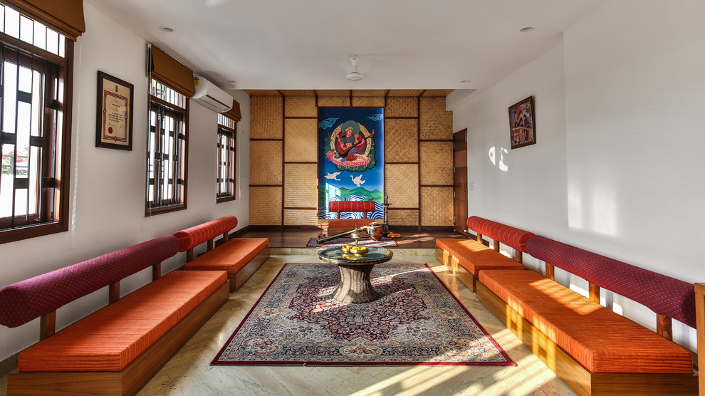 This is an example of a mid-sized asian family room in Delhi with white walls, light hardwood floors and beige floor.