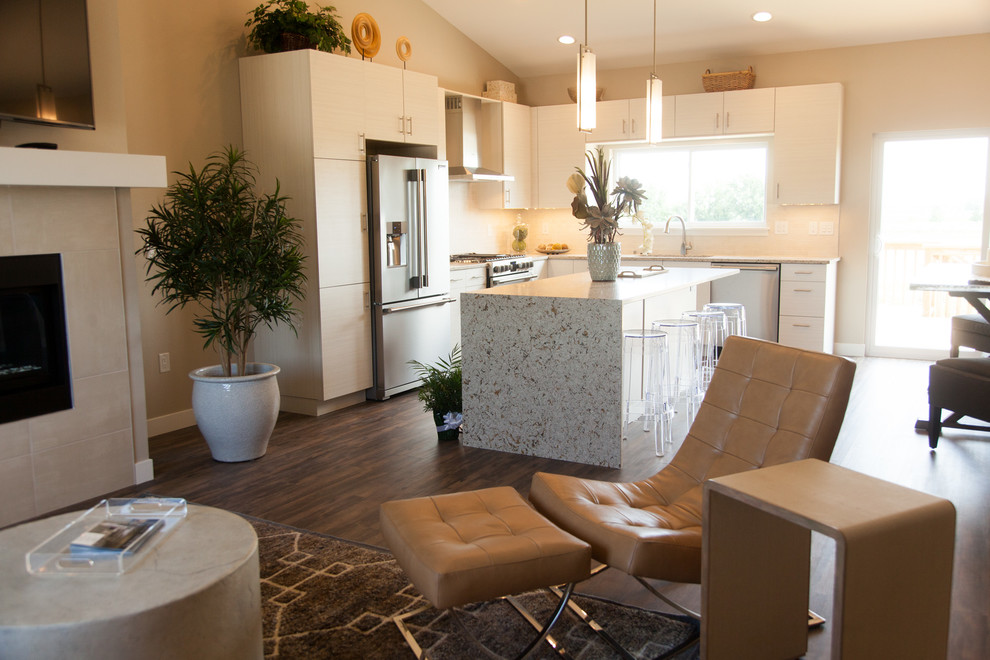 Example of a small minimalist l-shaped medium tone wood floor open concept kitchen design in Cedar Rapids with an undermount sink, flat-panel cabinets, light wood cabinets, quartz countertops, beige backsplash, stone tile backsplash, stainless steel appliances and an island