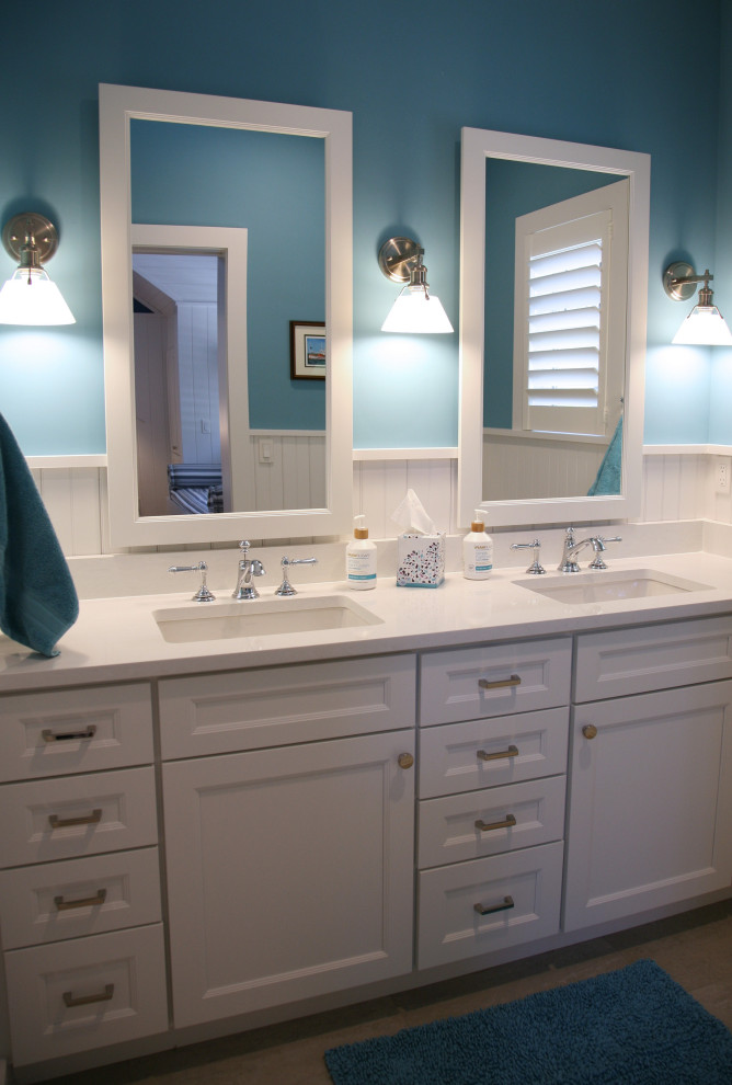 Photo of a mid-sized beach style kids bathroom in Milwaukee with flat-panel cabinets, white cabinets, blue tile, blue walls, cement tiles, an undermount sink, engineered quartz benchtops, beige floor, white benchtops, an enclosed toilet, a double vanity, a built-in vanity and wood walls.