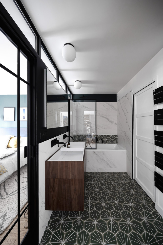 Mid-sized transitional master bathroom in Paris with beaded inset cabinets, dark wood cabinets, an undermount tub, a two-piece toilet, black and white tile, marble, green walls, cement tiles, a trough sink, solid surface benchtops, green floor, white benchtops, a double vanity and a floating vanity.