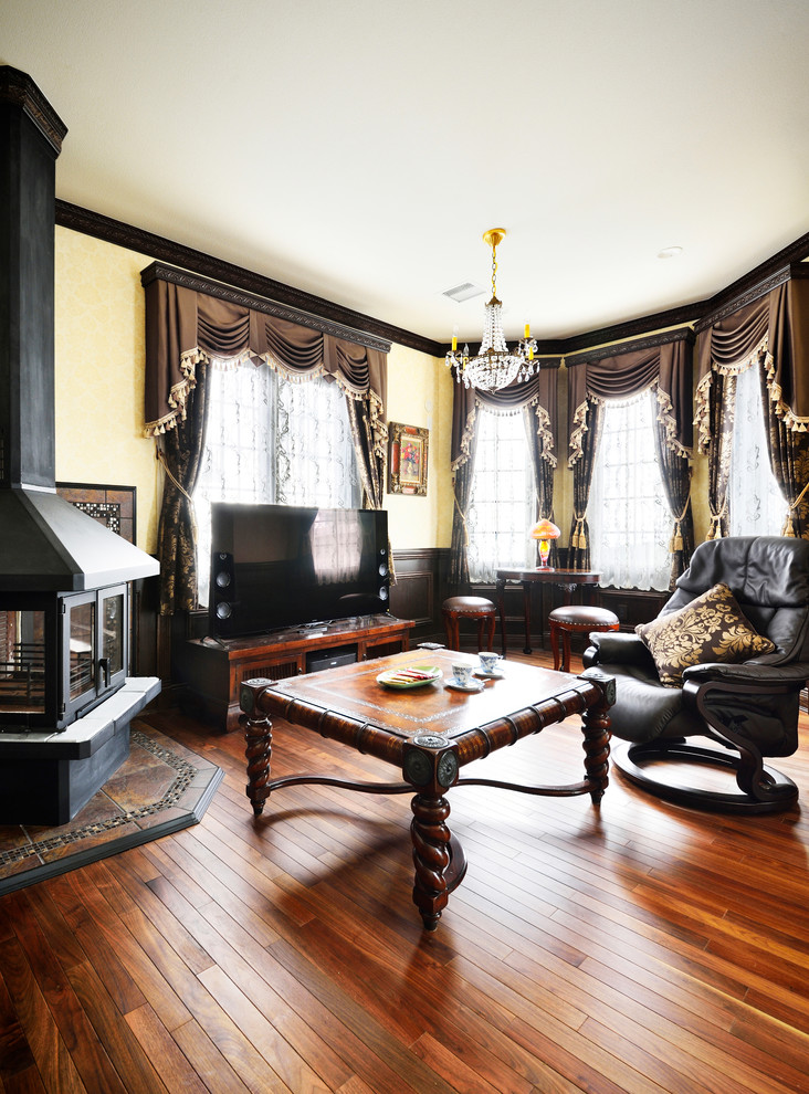 Photo of a traditional living room in Tokyo Suburbs with yellow walls, medium hardwood floors and brown floor.
