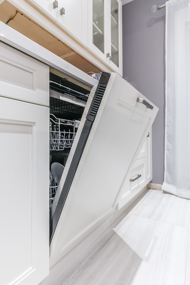 Eat-in kitchen - mid-sized transitional l-shaped porcelain tile eat-in kitchen idea in Toronto with a drop-in sink, recessed-panel cabinets, white cabinets, quartz countertops, stainless steel appliances and an island
