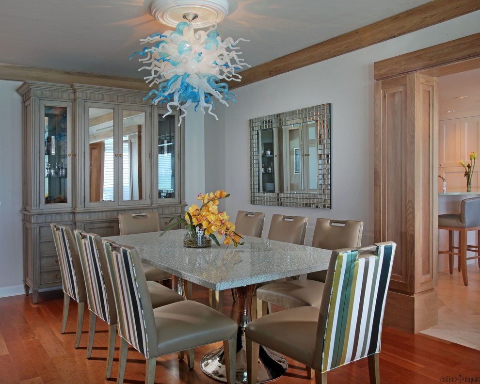 Example of a mid-sized transitional medium tone wood floor enclosed dining room design in Miami with white walls