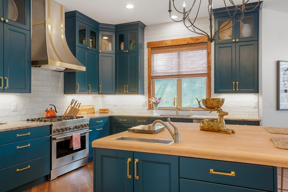Example of a large transitional u-shaped exposed beam open concept kitchen design in Denver with an undermount sink, recessed-panel cabinets, blue cabinets, wood countertops, white backsplash, stainless steel appliances and an island