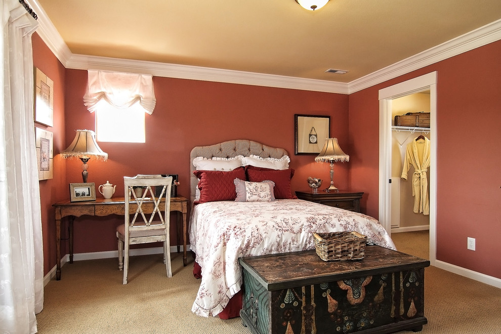 This is an example of a mediterranean guest bedroom in Denver with orange walls, carpet and beige floor.
