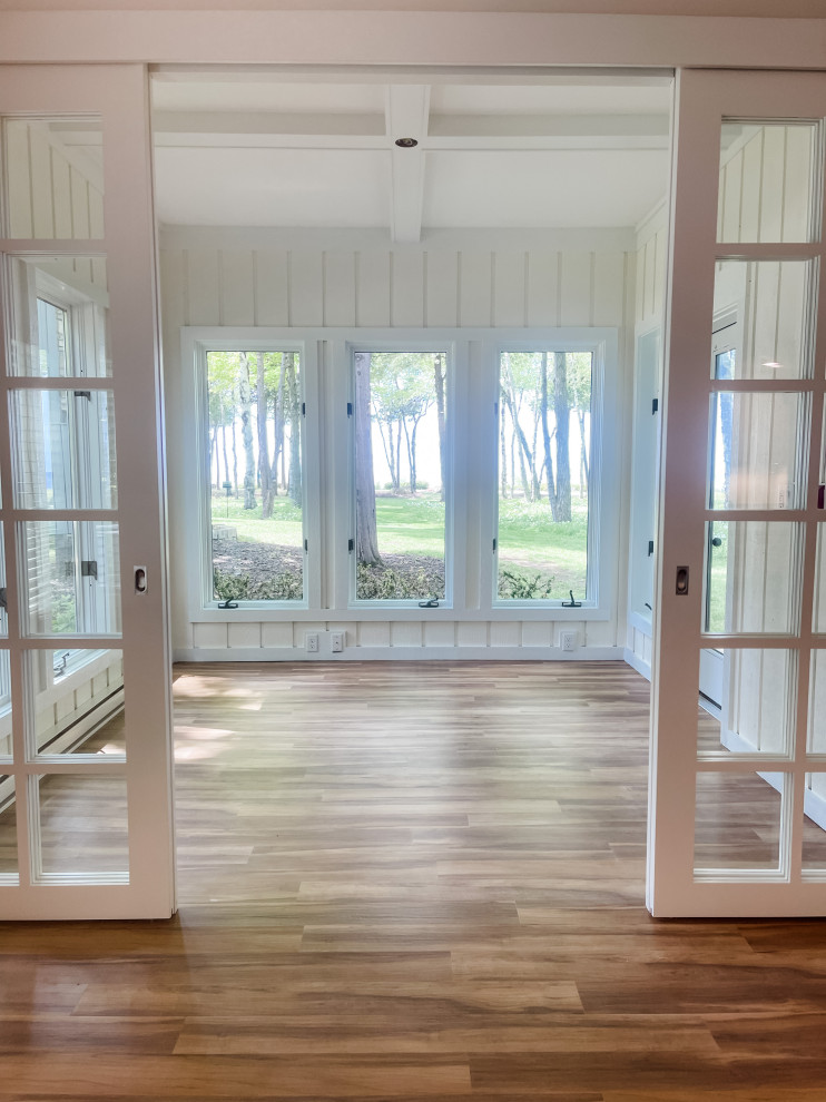 Ejemplo de galería minimalista de tamaño medio con suelo de madera clara, techo estándar y suelo marrón