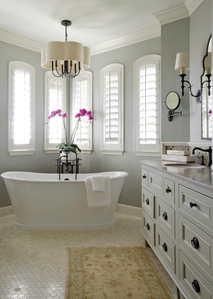 Design ideas for a mid-sized traditional master bathroom in Austin with an undermount sink, grey cabinets, limestone benchtops, a freestanding tub, a corner shower, white tile, stone tile, blue walls, travertine floors and recessed-panel cabinets.