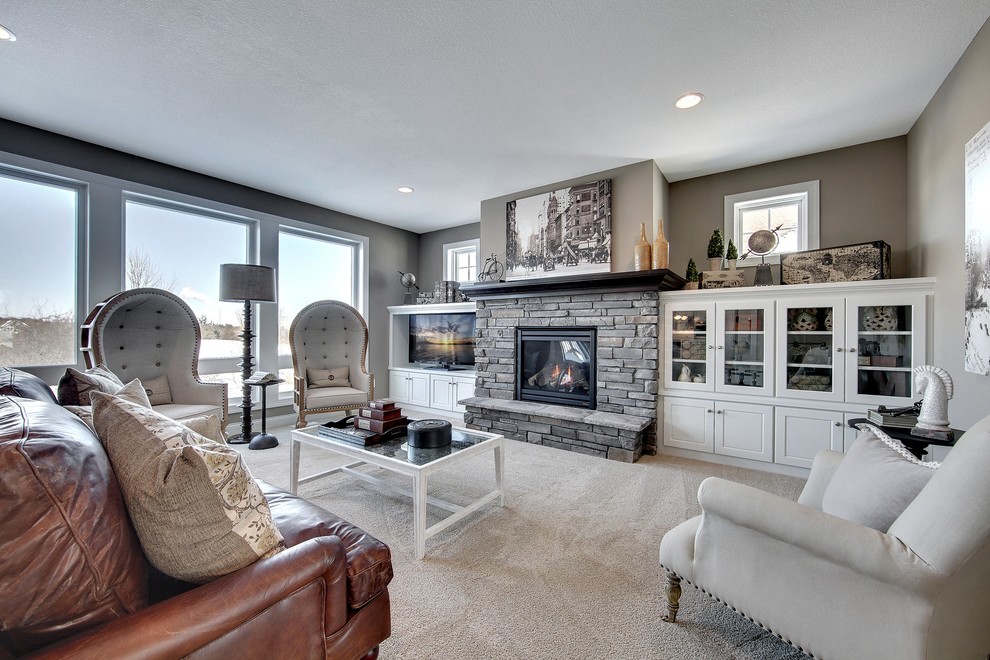 Photo of a large transitional open concept living room in Minneapolis with grey walls, carpet, a standard fireplace, a stone fireplace surround and a built-in media wall.