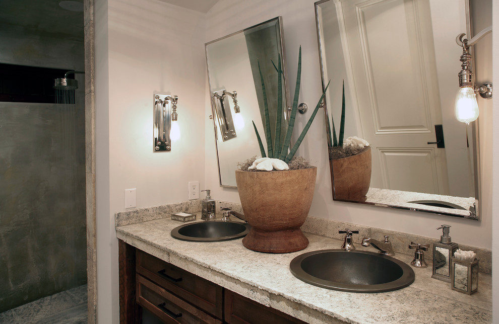 Inspiration for a small mediterranean master bathroom in Orange County with an undermount sink, furniture-like cabinets, dark wood cabinets, limestone benchtops, an alcove shower, a one-piece toilet, beige tile, stone tile, multi-coloured walls and limestone floors.