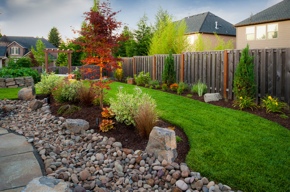 Traditional garden in Portland with with rock feature and river rock.