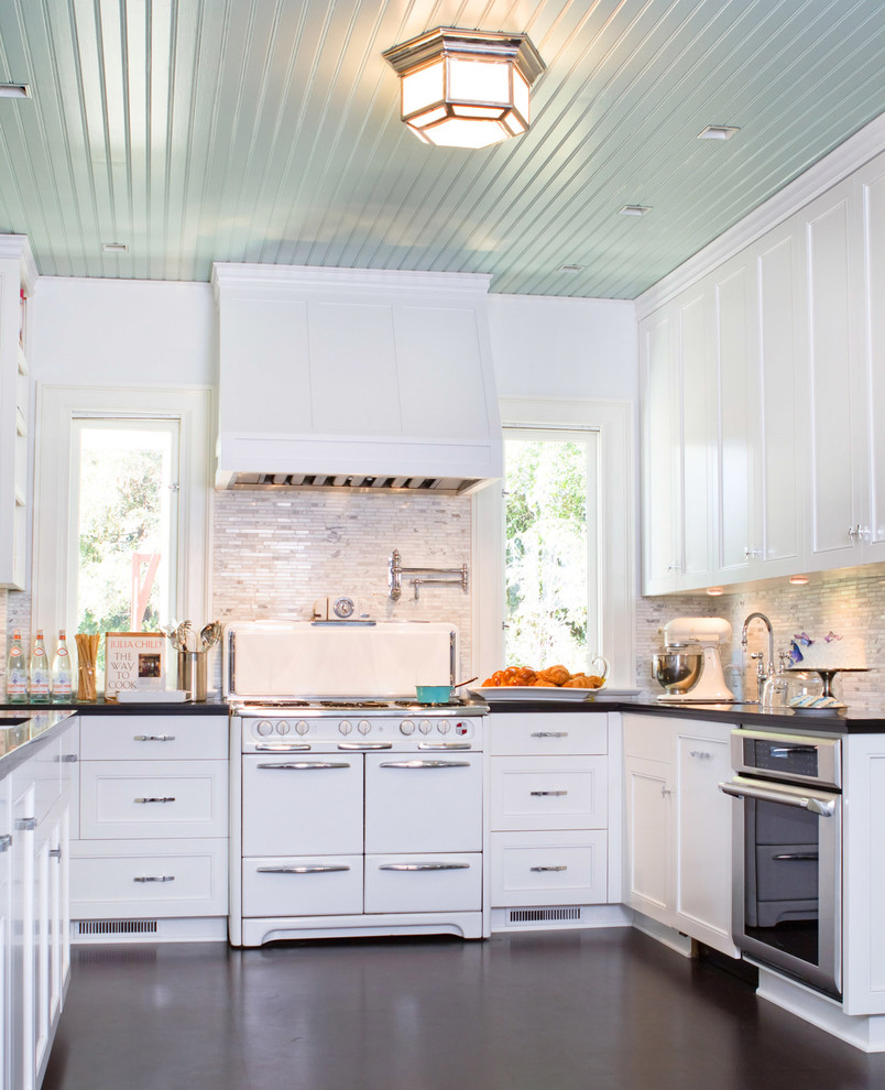 Photo of a traditional u-shaped kitchen in Los Angeles with recessed-panel cabinets, white appliances and white cabinets.