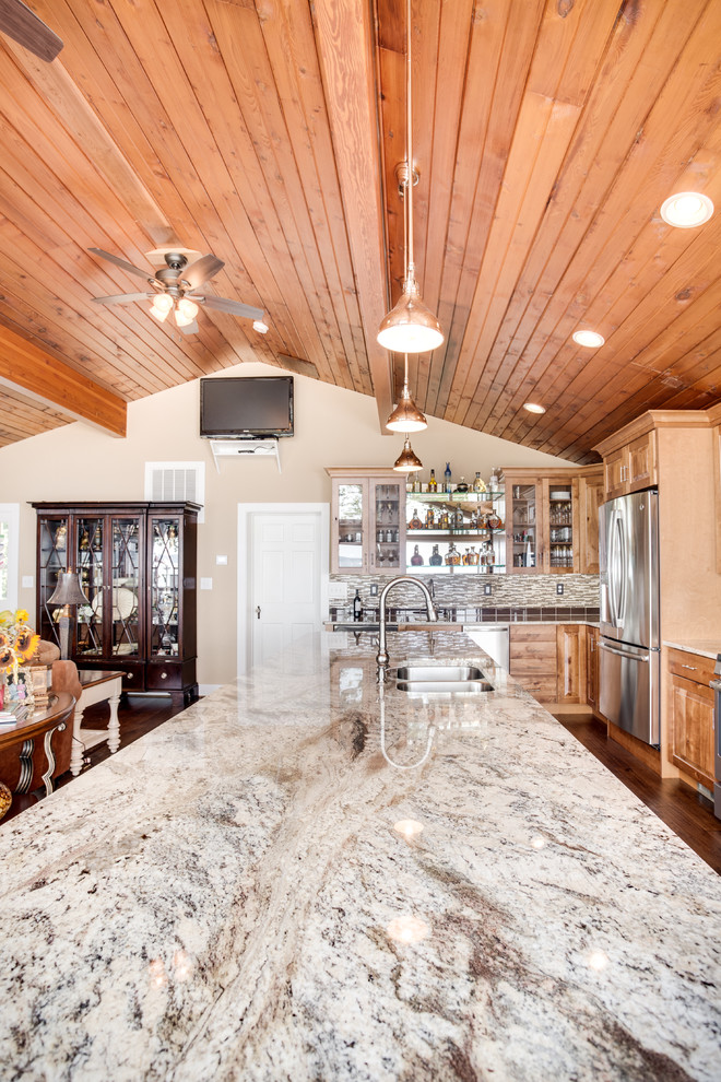 Example of a large mountain style kitchen design in DC Metro with an undermount sink, raised-panel cabinets, granite countertops, glass tile backsplash, stainless steel appliances and an island