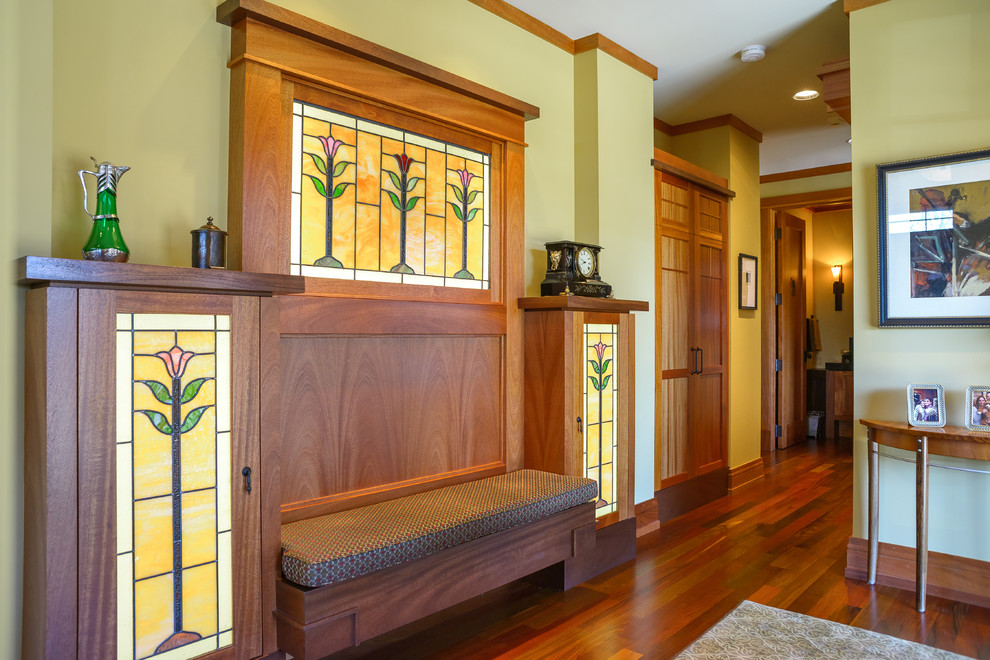 This is an example of an arts and crafts hallway in Minneapolis with dark hardwood floors and yellow walls.