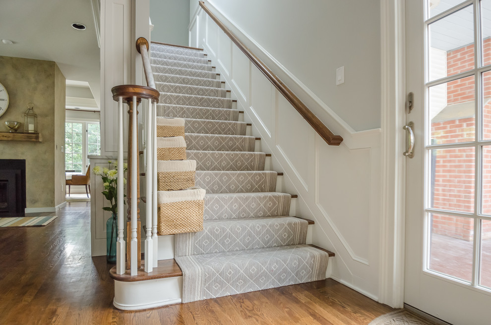This is an example of a mid-sized traditional wood straight staircase in New York with painted wood risers.