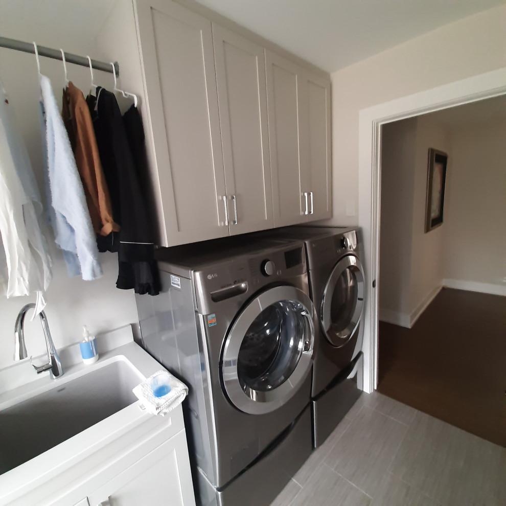 Foto di una piccola sala lavanderia tradizionale con lavello sottopiano, ante con riquadro incassato, ante bianche, top in quarzo composito, lavatrice e asciugatrice affiancate e top bianco