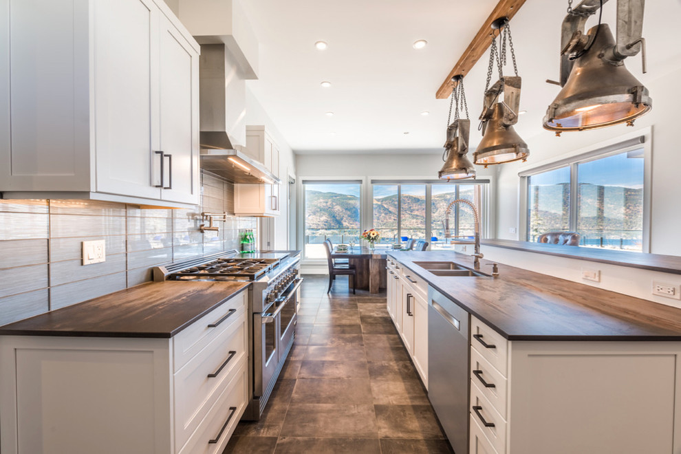 Inspiration for a large contemporary galley eat-in kitchen in Vancouver with an undermount sink, shaker cabinets, white cabinets, solid surface benchtops, grey splashback, glass tile splashback, stainless steel appliances, porcelain floors, with island and brown floor.