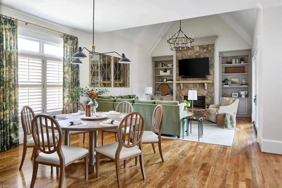 Dining room - large transitional medium tone wood floor and vaulted ceiling dining room idea in Atlanta with a stone fireplace