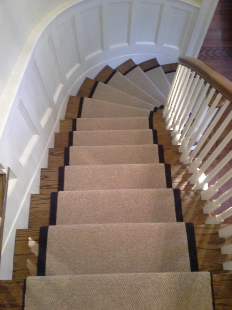 This is an example of a traditional carpeted curved staircase in New York with carpet risers.