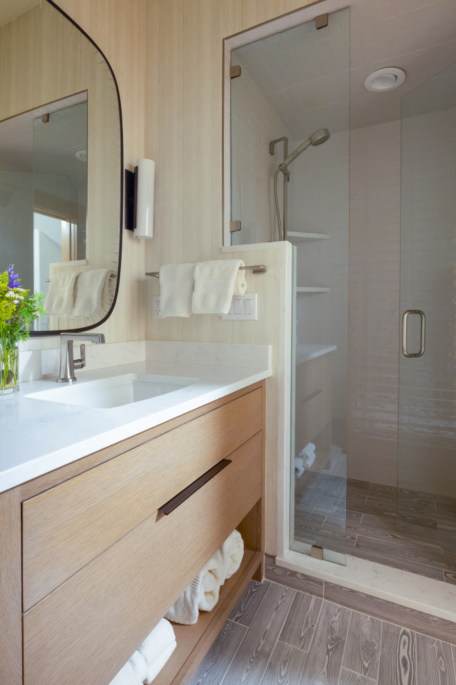 Exemple d'une petite douche en alcôve principale tendance en bois clair avec un placard à porte plane, un sol en carrelage de porcelaine, un plan de toilette en quartz modifié, un plan de toilette blanc, meuble simple vasque et meuble-lavabo encastré.