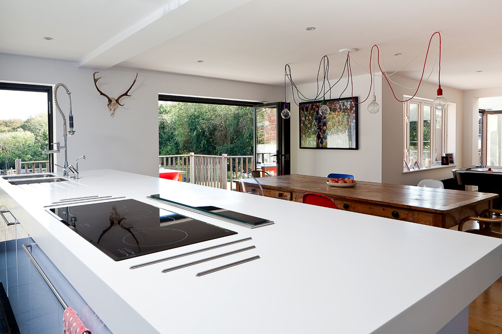 This is an example of a contemporary open plan kitchen in London with a double-bowl sink, flat-panel cabinets and white cabinets.