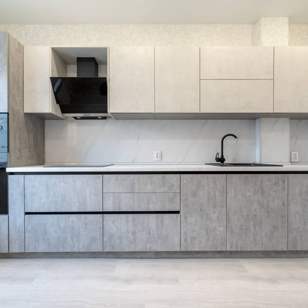 Большая светлая прямая кухня с фасадами под металл и камень