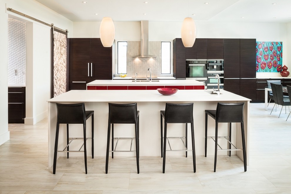Contemporary eat-in kitchen in Houston with an undermount sink, flat-panel cabinets, dark wood cabinets, beige splashback, glass tile splashback, panelled appliances and multiple islands.