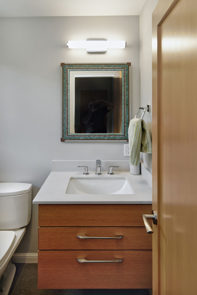 Immagine di una piccola stanza da bagno design con ante lisce, ante in legno scuro, pareti grigie, pavimento in gres porcellanato, lavabo sottopiano, top in quarzo composito, pavimento grigio, top bianco, un lavabo e mobile bagno sospeso