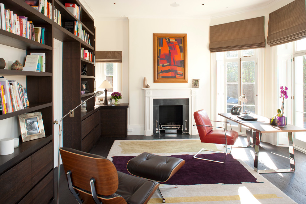 Photo of a contemporary home office in London with white walls, dark hardwood floors, a standard fireplace and a freestanding desk.
