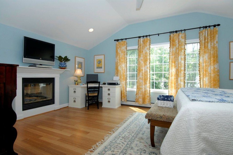 Large traditional master bedroom in DC Metro with blue walls, medium hardwood floors, a standard fireplace, a wood fireplace surround and brown floor.