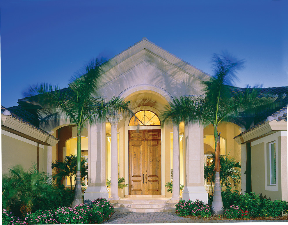 Large mediterranean one-storey stucco beige exterior in Miami with a hip roof.