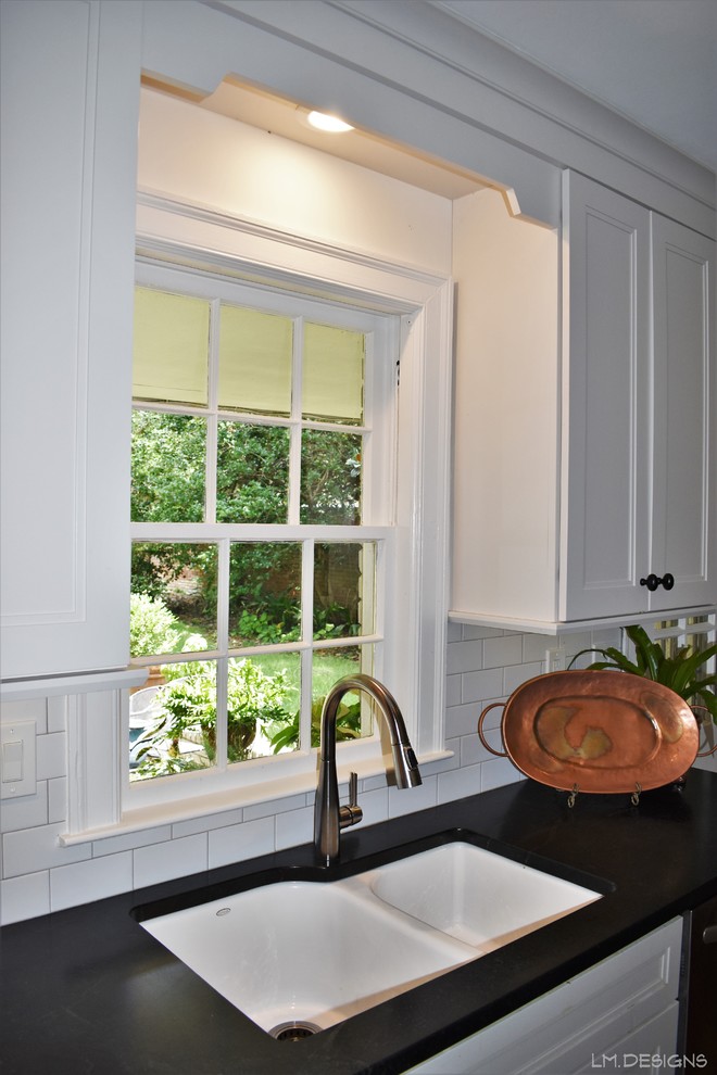 Inspiration for a transitional galley medium tone wood floor and brown floor kitchen remodel with an undermount sink, recessed-panel cabinets, white cabinets, soapstone countertops, white backsplash, subway tile backsplash, stainless steel appliances and black countertops
