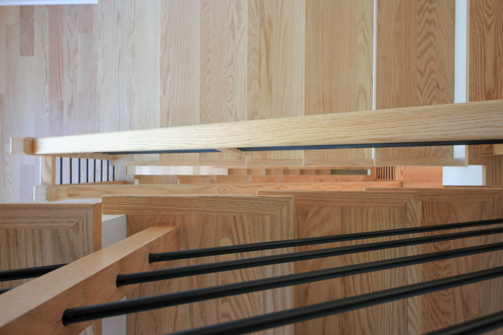 Immagine di una scala sospesa contemporanea di medie dimensioni con pedata in legno, alzata in legno verniciato, parapetto in materiali misti e pareti in perlinato