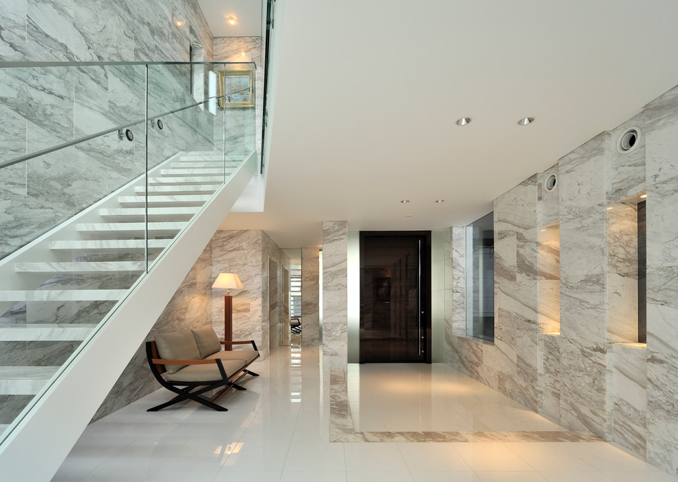 東京23区にあるコンテンポラリースタイルのおしゃれな玄関ラウンジ (黒いドア、白い壁、大理石の床、白い床) の写真