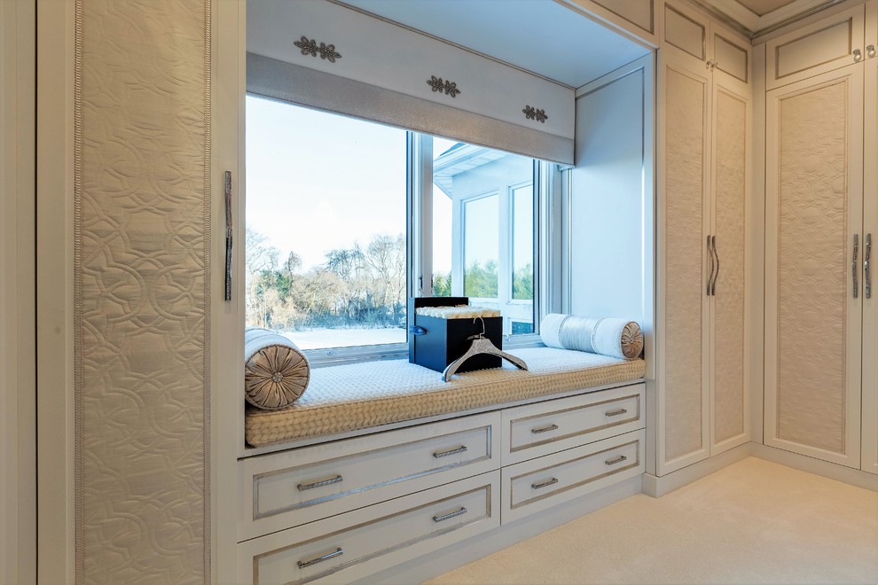 Large transitional women's walk-in wardrobe in New York with recessed-panel cabinets and white cabinets.