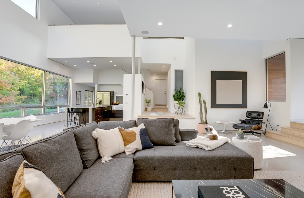 Large contemporary open concept living room in Grand Rapids with white walls, porcelain floors and beige floor.