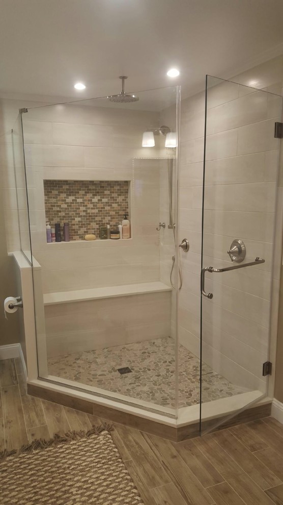 Inspiration for a mid-sized traditional master bathroom in Newark with an alcove shower, a one-piece toilet, white tile, beige tile, brown tile, porcelain tile, beige walls, porcelain floors and marble benchtops.