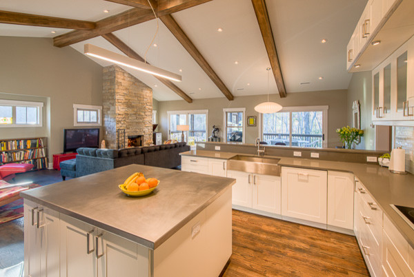 Trendy l-shaped medium tone wood floor eat-in kitchen photo with a farmhouse sink, shaker cabinets, white cabinets, stainless steel appliances, an island, quartz countertops and white backsplash