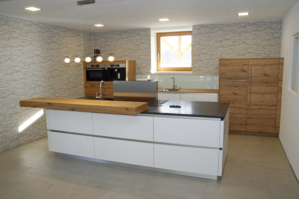 Mid-sized contemporary galley eat-in kitchen in Munich with an integrated sink, flat-panel cabinets, white cabinets, wood benchtops and multiple islands.