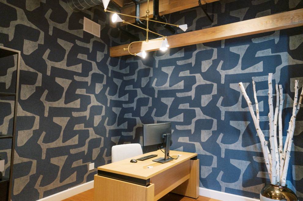 Diseño de estudio minimalista de tamaño medio con paredes multicolor, escritorio independiente, suelo de madera clara, suelo beige y papel pintado