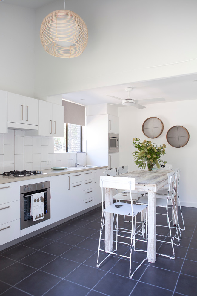 Mid-sized beach style single-wall kitchen in Brisbane with a drop-in sink, flat-panel cabinets and white cabinets.