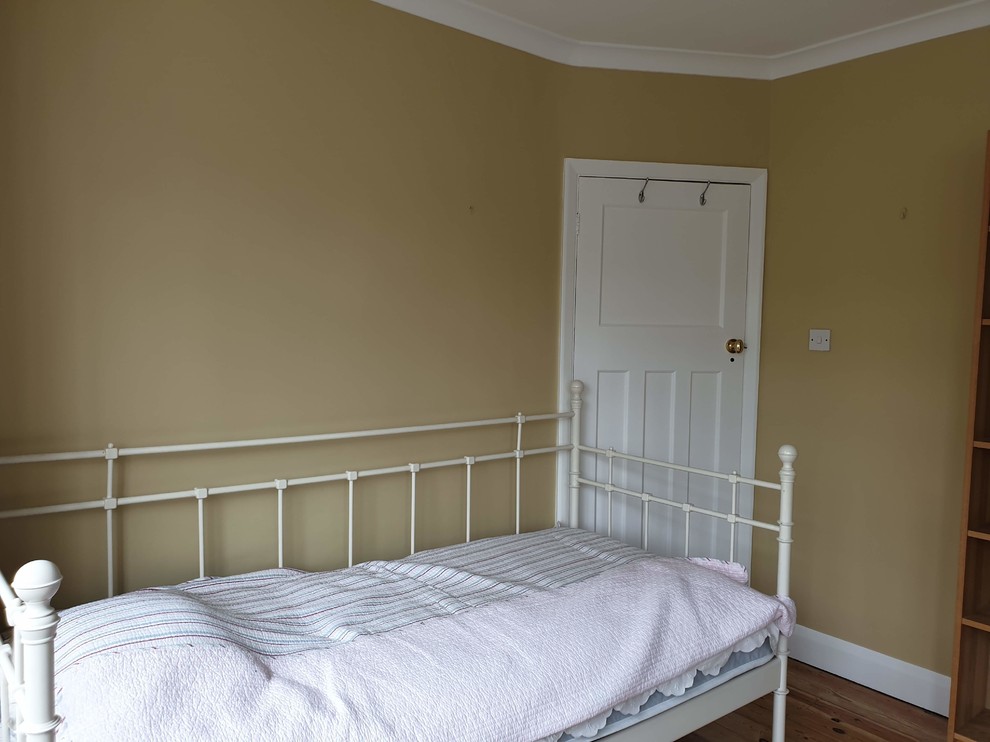 Ejemplo de dormitorio principal tradicional extra grande con paredes amarillas, suelo de madera en tonos medios, suelo marrón y bandeja