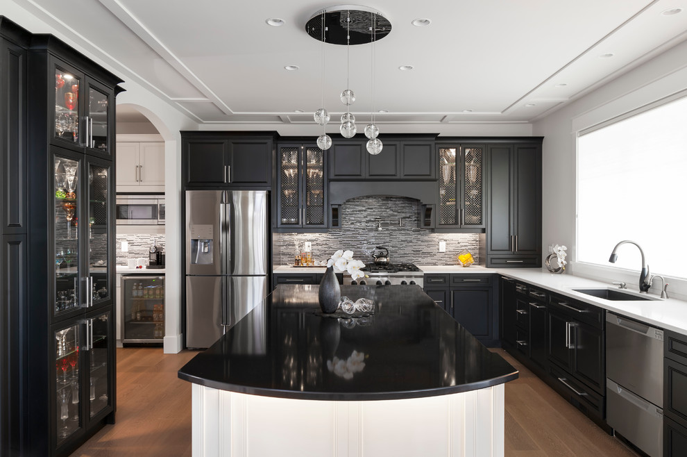 Kitchen pantry - large transitional u-shaped medium tone wood floor and brown floor kitchen pantry idea with an undermount sink, recessed-panel cabinets, black cabinets, quartz countertops, gray backsplash, glass tile backsplash, stainless steel appliances, an island and white countertops