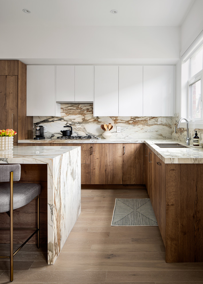 Inspiration for a large contemporary l-shaped eat-in kitchen in Toronto with a double-bowl sink, flat-panel cabinets, brown cabinets, wood benchtops, multi-coloured splashback, engineered quartz splashback, panelled appliances, light hardwood floors, with island, beige floor and multi-coloured benchtop.